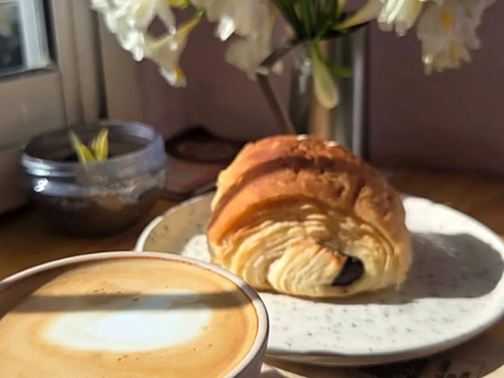 Café con medialuna y flores